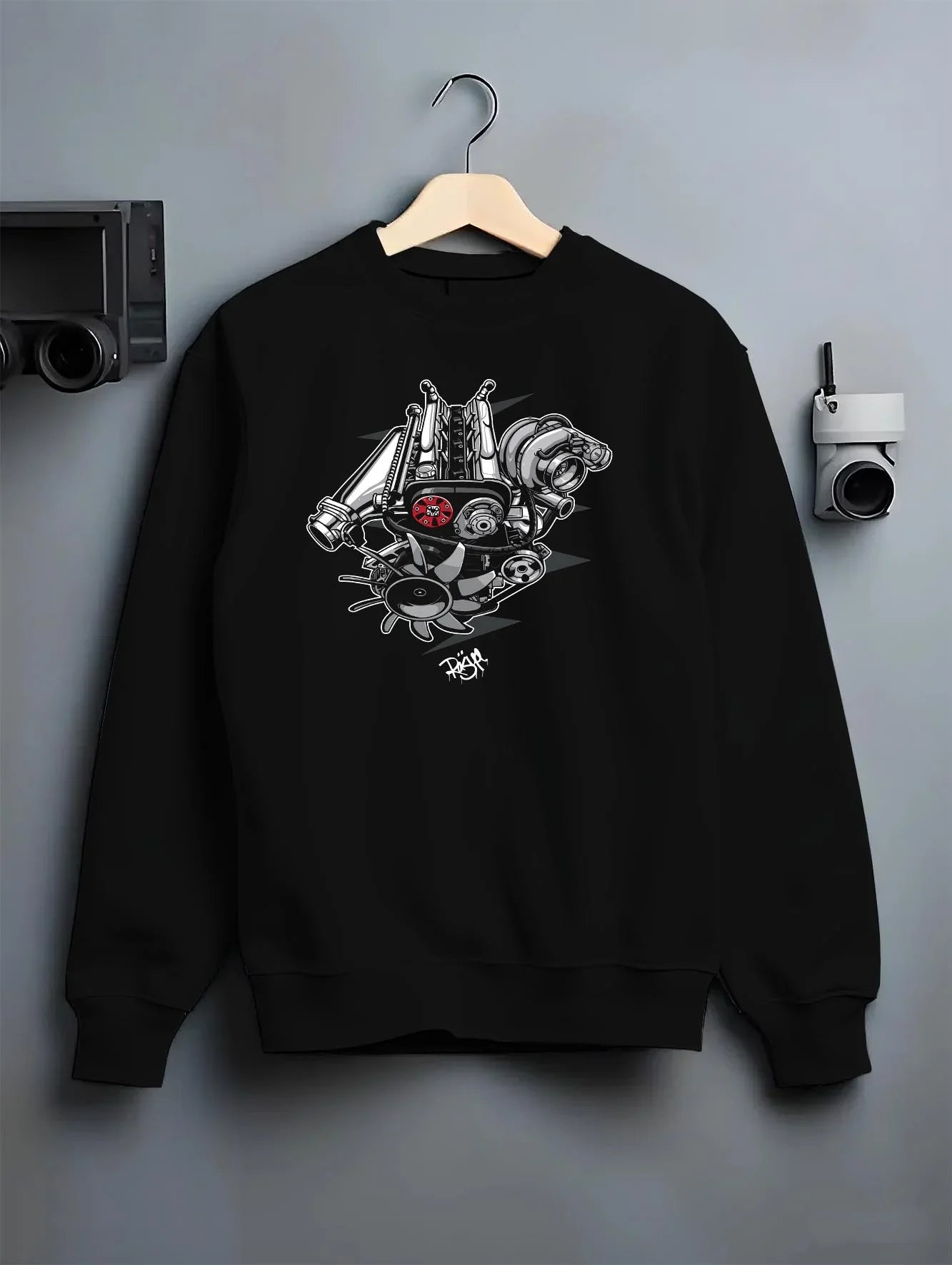 Black crewneck sweatshirt on a hanger against a grey wall, featuring muscle retro vintage racing street performance graphic.