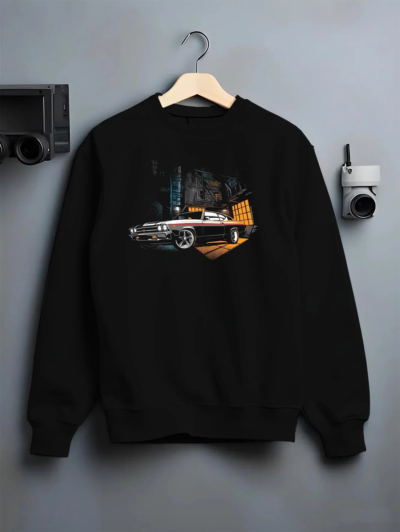 Black crewneck sweatshirt on a hanger against a grey wall, featuring Chevrolet Chevelle rs american muscle retro classic graphic.