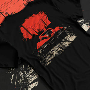 Black T-shirt laid flat with natural fabric folds, featuring Chevrolet Corvette muscle retro classic enthusiast racing graphic.