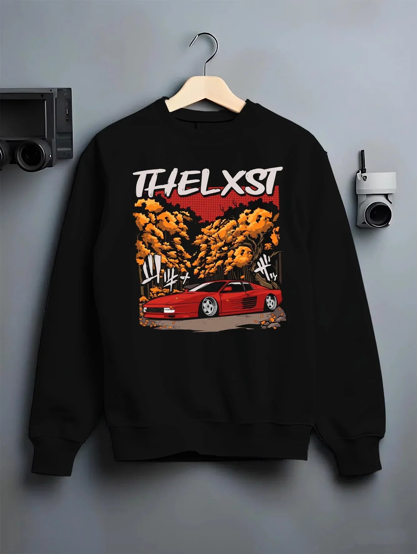 Black crewneck sweatshirt on a hanger against a grey wall, featuring Ferrari rs racing italian power street performance graphic.