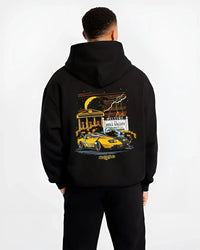 Black hoodie worn by a male model, back view, featuring racing street retro performance motorsport automotive enthusiast graphic.