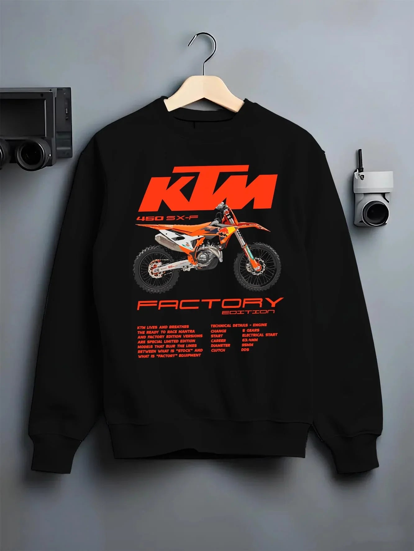 Black crewneck sweatshirt on a hanger against a grey wall, featuring KTM 250 SX rs racing street performance motorsport graphic.