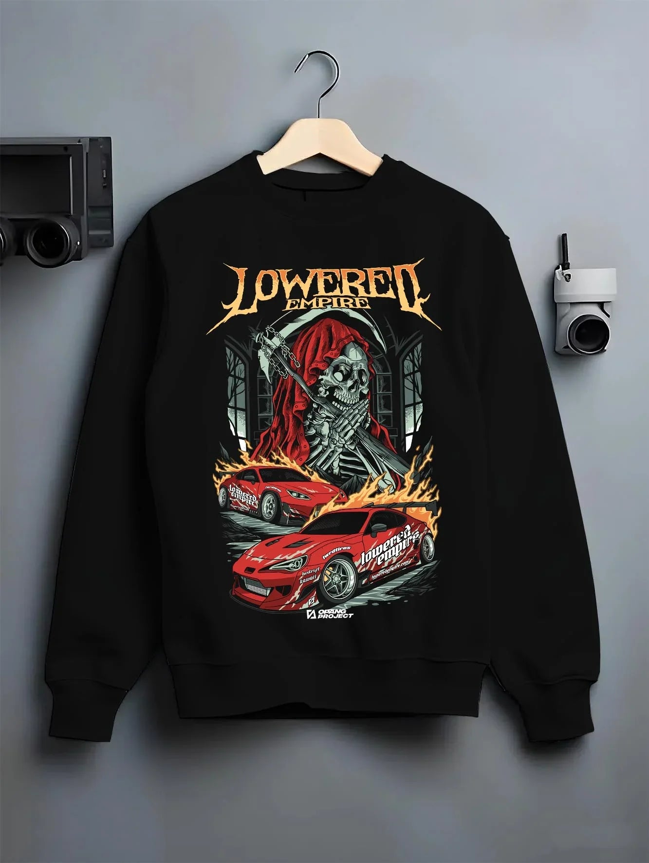 Black crewneck sweatshirt on a hanger against a grey wall, featuring rs racing drift lowered street performance motorsport graphic.