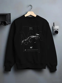Black crewneck sweatshirt on a hanger against a grey wall, featuring BMW M4 gt3 racing race gran turismo street performance graphic.