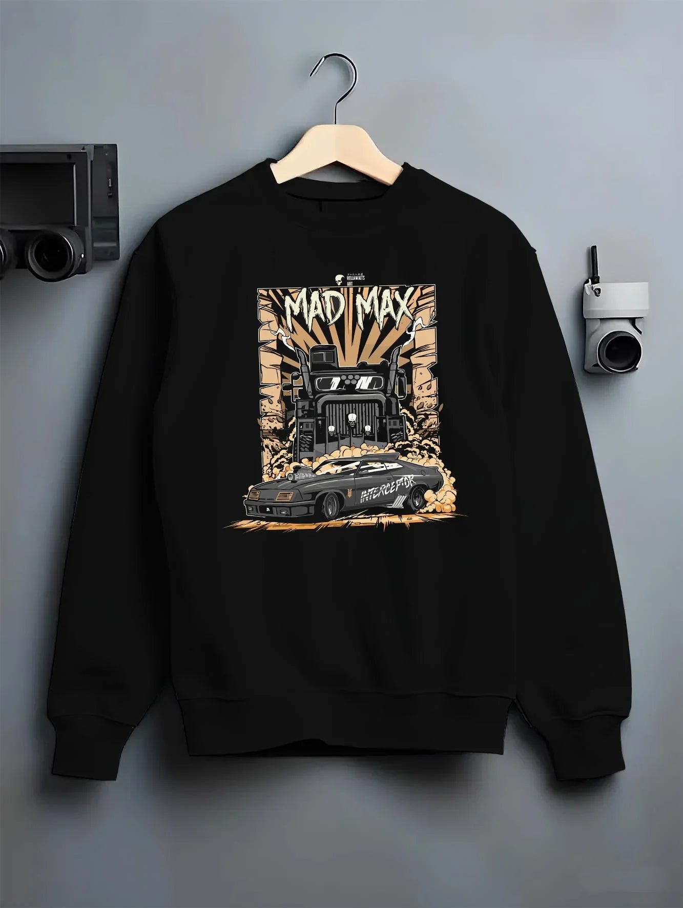 Black crewneck sweatshirt on a hanger against a grey wall, featuring enthusiast racing street performance motorsport madmx.