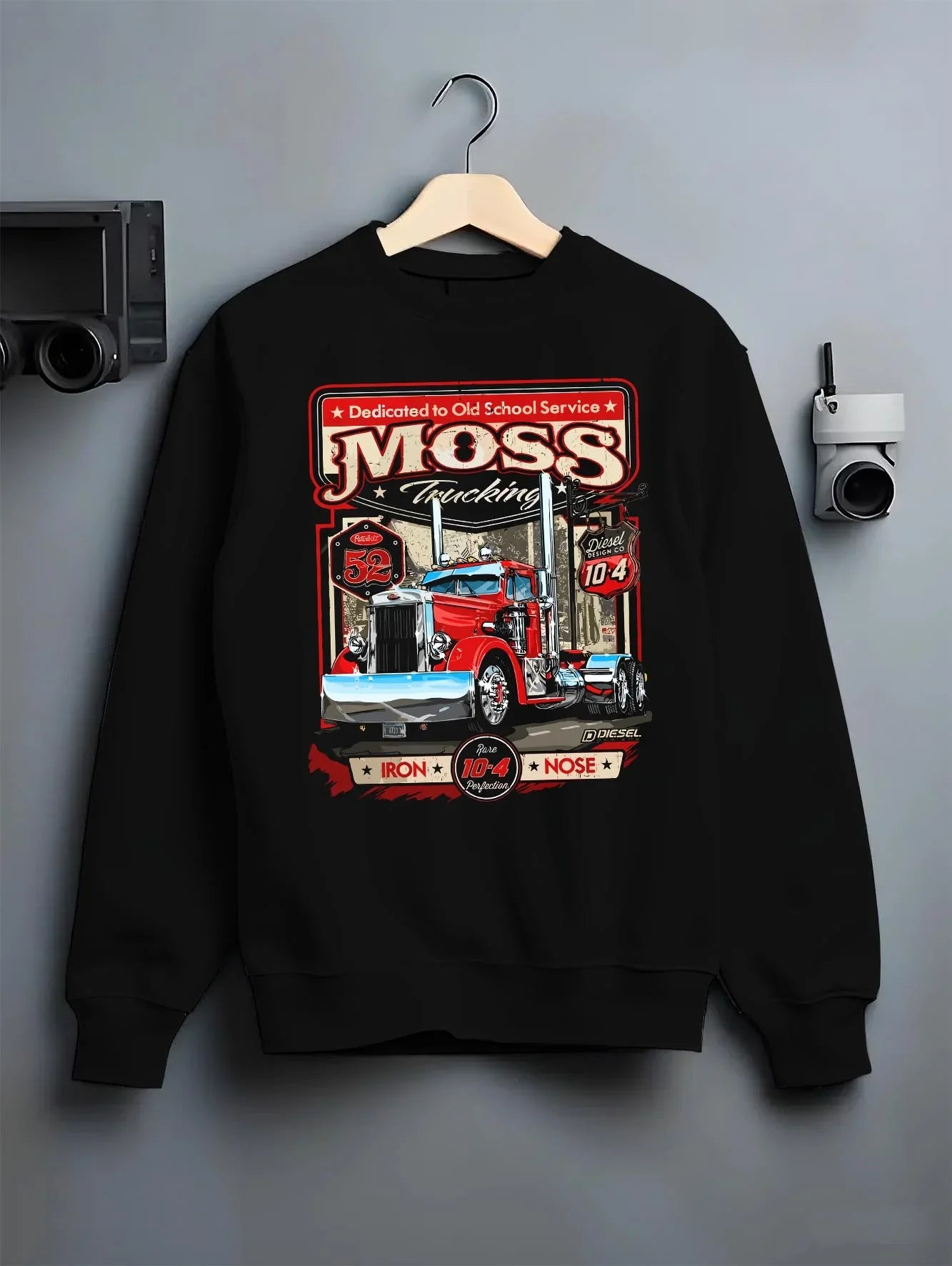 Black crewneck sweatshirt on a hanger against a grey wall, featuring american retro vintage racing street performance graphic.