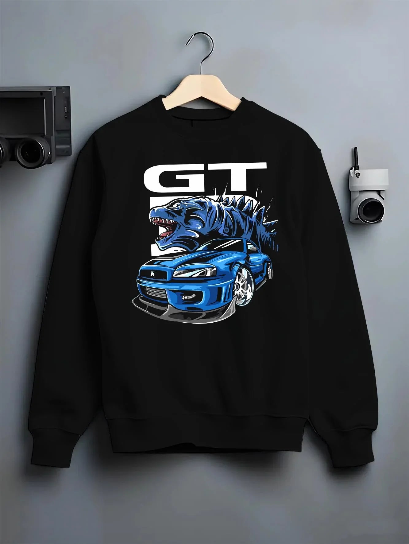 Black crewneck sweatshirt on a hanger against a grey wall, featuring Nissan GT-R R34 gt r r34 skyline turbo drift jdm graphic.