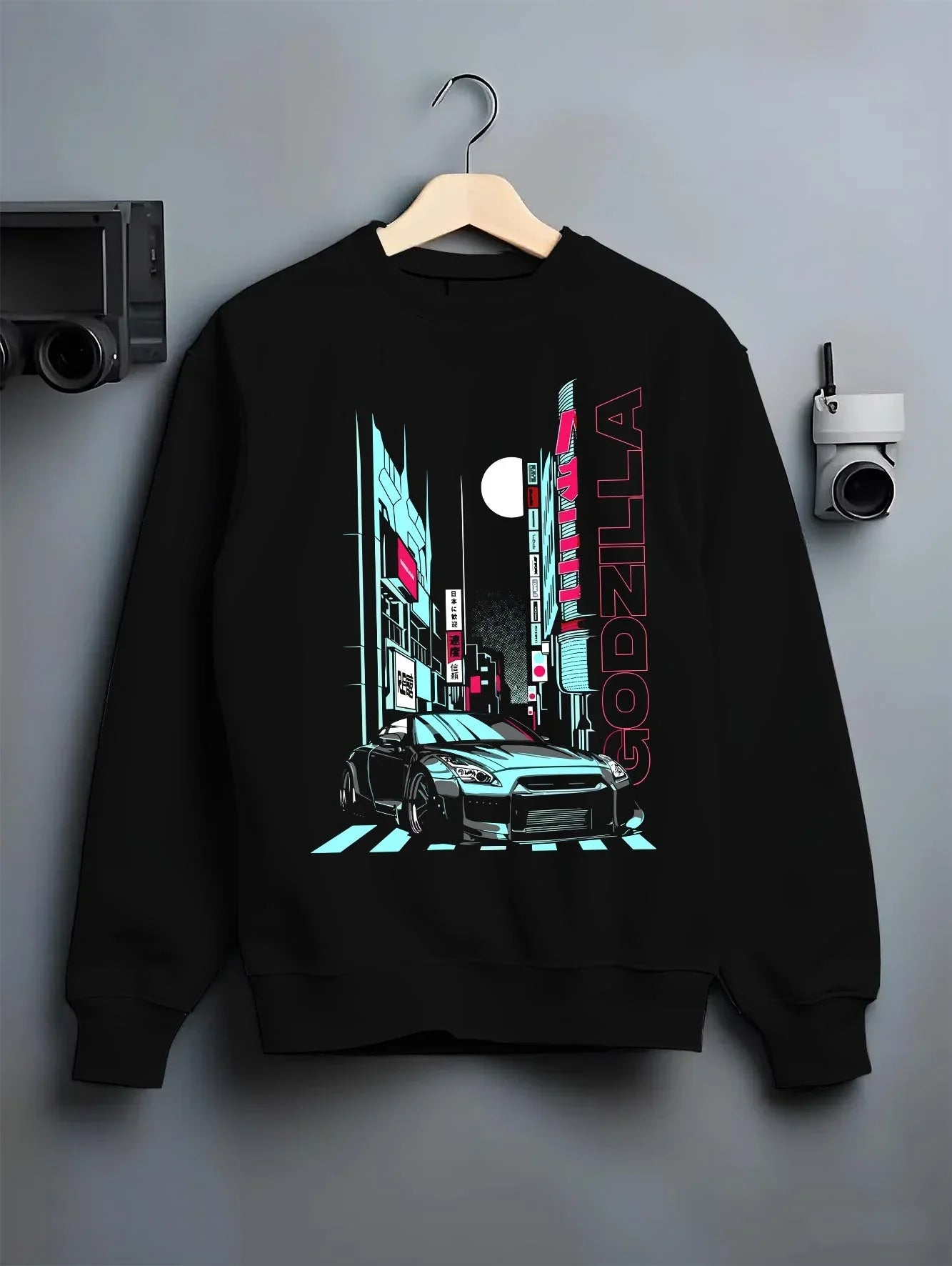 Black crewneck sweatshirt on a hanger against a grey wall, featuring Nissan GT-R gtr skyline racing drift jdm japanese graphic.