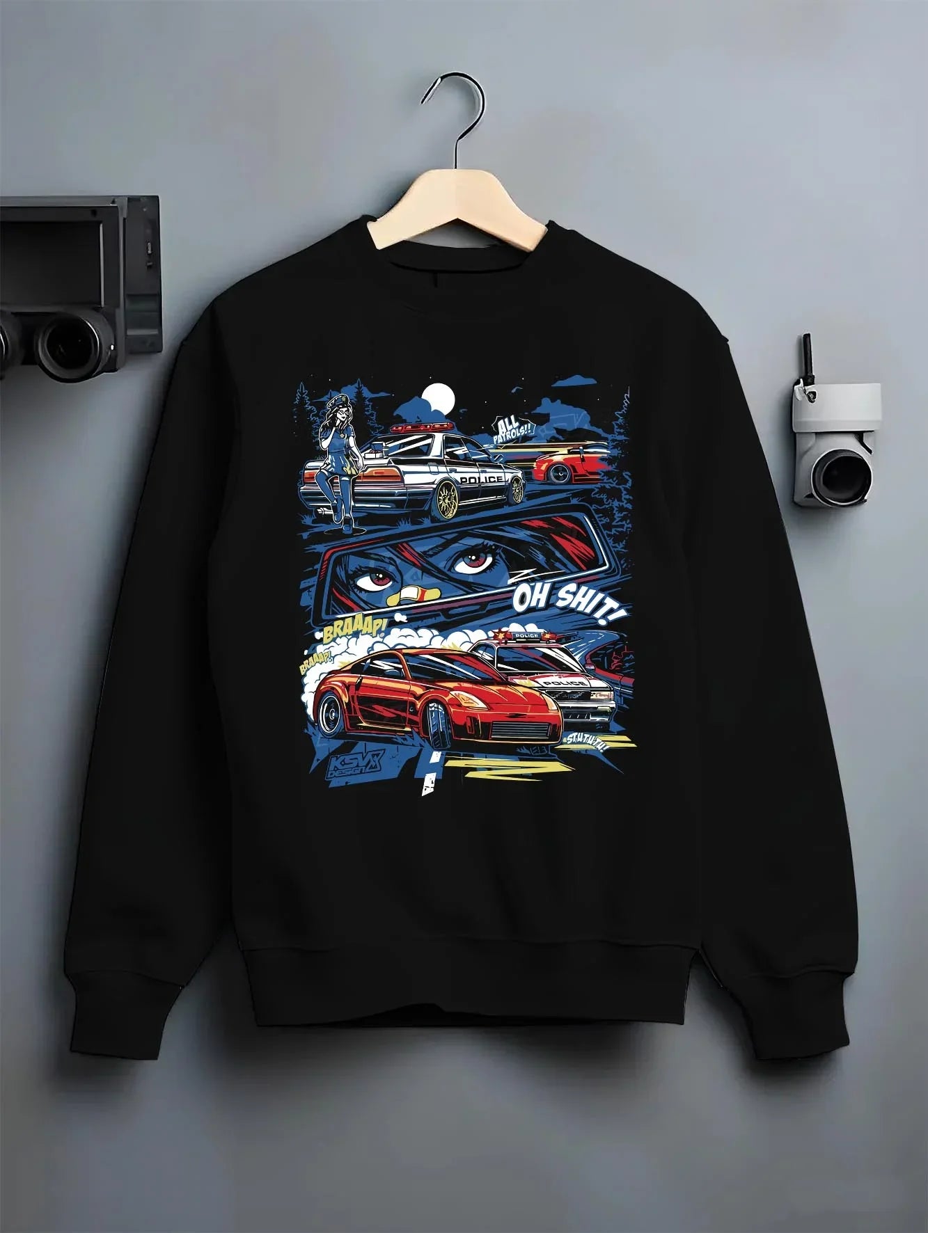 Black crewneck sweatshirt on a hanger against a grey wall, featuring STI street racing performance motorsport automotive police.