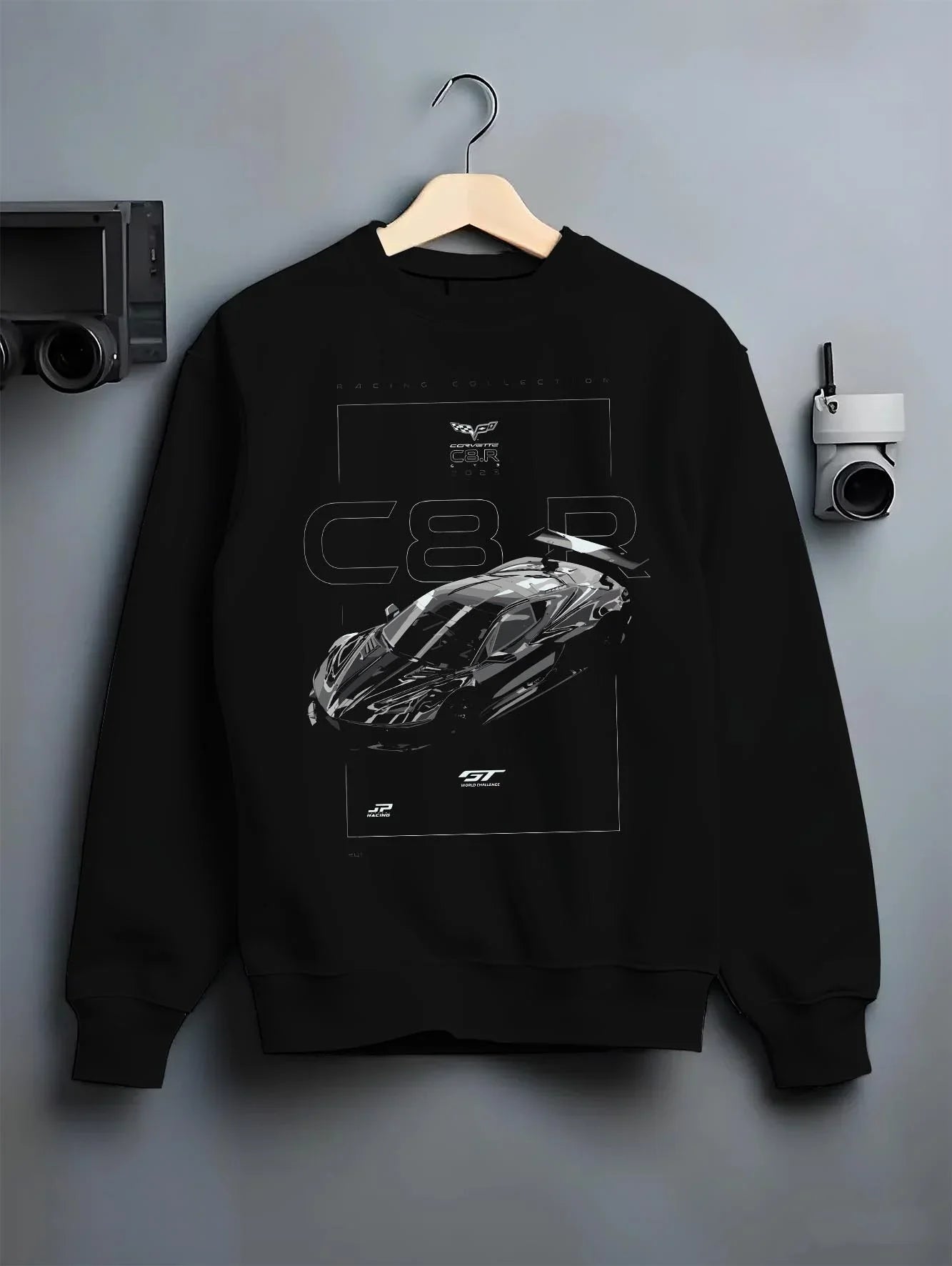 Black crewneck sweatshirt on a hanger against a grey wall, featuring Chevrolet Corvette C6 corvette racing muscle street graphic.